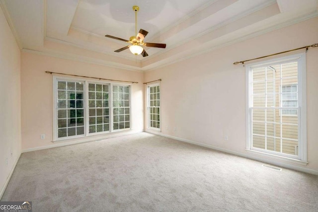2430 Harbin Springs Cv, Dacula, GA 30019 - spare room featuring a tray ceiling, ornamental molding, a ceiling fan, carpet flooring, and baseboards