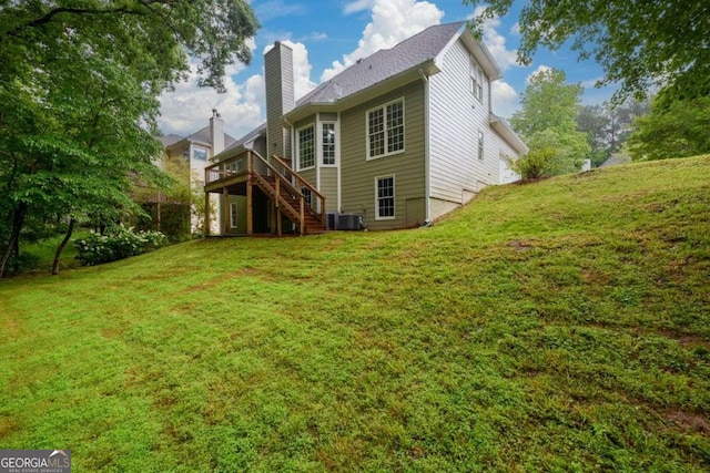 2430 Harbin Springs Cv, Dacula, GA 30019 - rear view of house with stairs, a chimney, a lawn, a wooden deck, and central AC unit