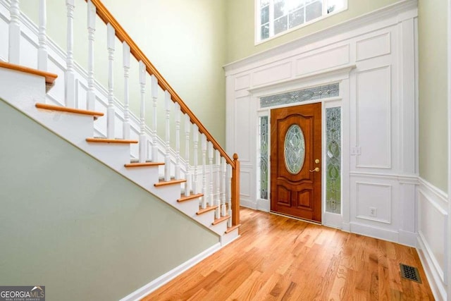 2430 Harbin Springs Cv, Dacula, GA 30019 - foyer featuring a decorative wall, a towering ceiling, stairs, and light wood-style flooring