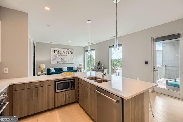 775 Juniper St NE Unit 612, Atlanta, GA 30308 - kitchen with appliances with stainless steel finishes, a sink, open floor plan, light countertops, and light wood-style flooring