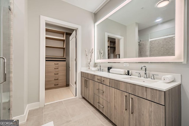 775 Juniper St NE Unit 612, Atlanta, GA 30308 - bathroom featuring a walk in closet, a shower stall, double vanity, and tile patterned flooring