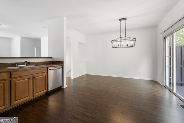 kitchen with dishwasher, dark countertops, dark wood finished floors, and a sink