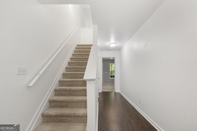 stairs with wood finished floors and baseboards
