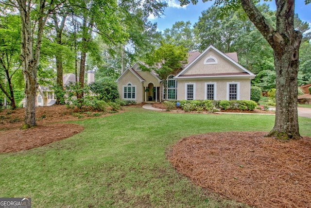 view of front of house with stucco siding and a front lawn