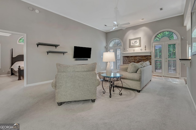 carpeted living area featuring a ceiling fan, baseboards, and crown molding