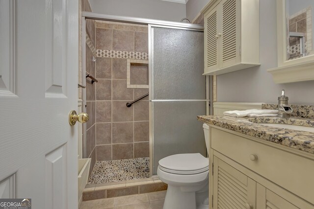 bathroom featuring a shower stall, toilet, vanity, and tile patterned flooring