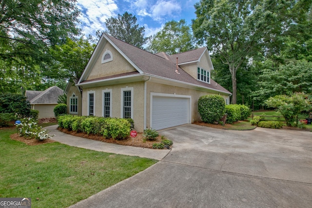 view of home's exterior featuring concrete driveway, stucco siding, a lawn, an attached garage, and roof with shingles