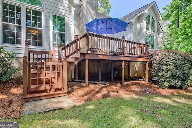 rear view of property featuring a deck, stairway, and a yard
