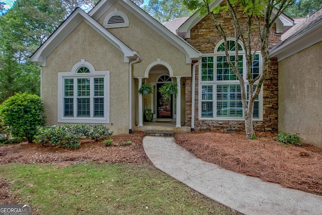 property entrance with stone siding and stucco siding