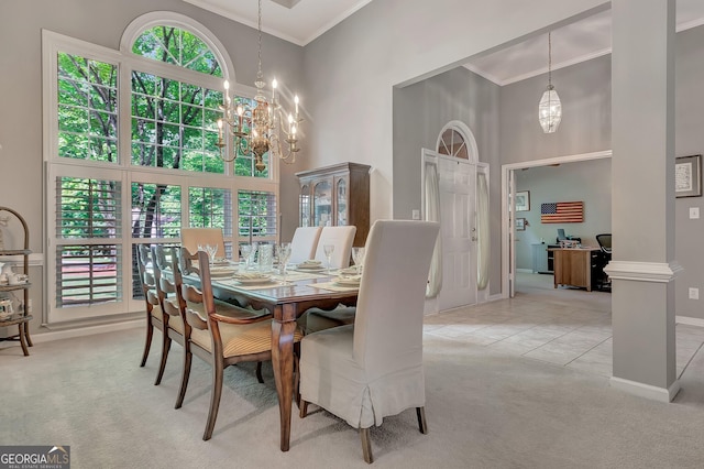 dining room featuring a towering ceiling, light carpet, a chandelier, ornamental molding, and baseboards