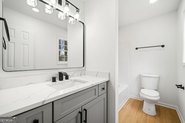 full bathroom featuring toilet, wood finished floors, vanity, and baseboards