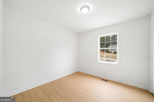 empty room with light wood-type flooring and baseboards