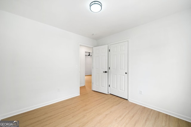 unfurnished bedroom with light wood finished floors and baseboards