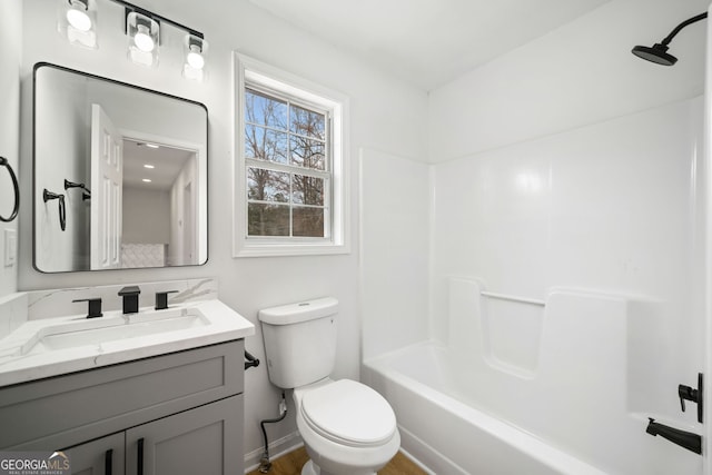 full bath featuring toilet, vanity, wood finished floors, baseboards, and tub / shower combination