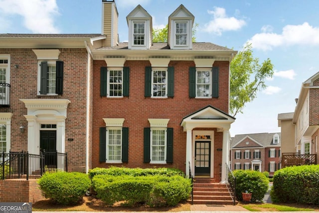 georgian-style home with brick siding and a chimney