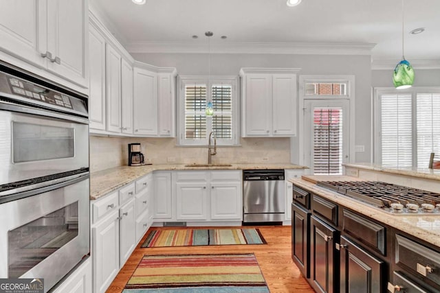 kitchen with appliances with stainless steel finishes, a sink, white cabinets, dark brown cabinetry, and recessed lighting