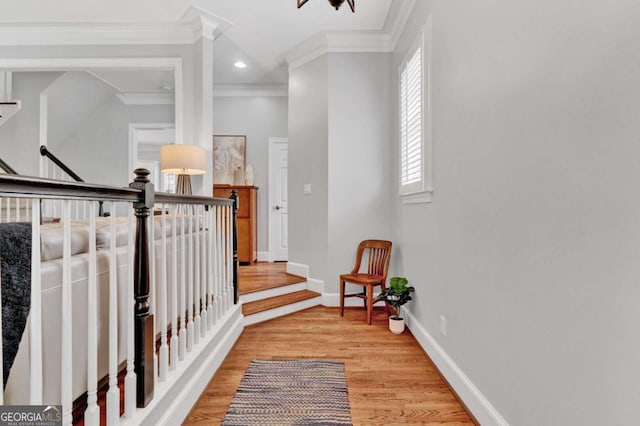 hallway featuring crown molding, light wood finished floors, an upstairs landing, baseboards, and recessed lighting