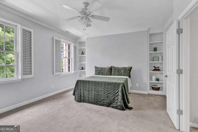 carpeted bedroom with crown molding, baseboards, and a ceiling fan