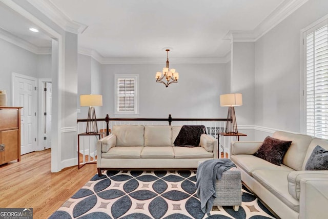 living area featuring a chandelier, light wood-style flooring, crown molding, and recessed lighting