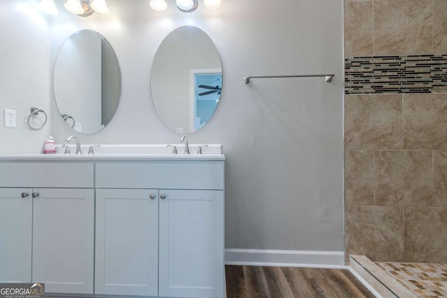 233 Clayton St, Fairburn, GA 30213 - bathroom featuring double vanity, tiled shower, and wood finished floors