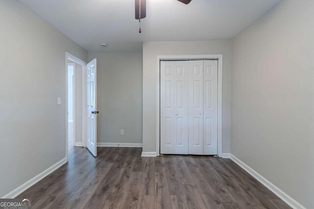 233 Clayton St, Fairburn, GA 30213 - unfurnished bedroom with dark wood-style floors, baseboards, and a closet