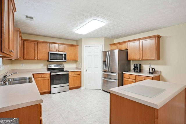 4549 Clarks Creek Ter, Ellenwood, GA 30294 - kitchen with appliances with stainless steel finishes, a sink, light countertops, a textured ceiling, and light flooring