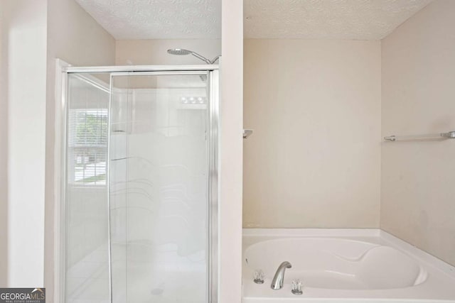 4549 Clarks Creek Ter, Ellenwood, GA 30294 - bathroom featuring a shower stall, a garden tub, and a textured ceiling
