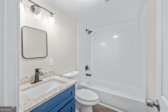 610 Ash Ln, Monroe, GA 30655 - bathroom featuring toilet, vanity, washtub / shower combination, and wood finished floors