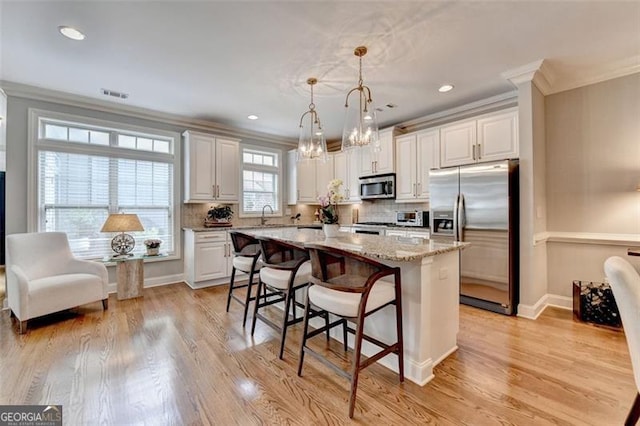 7435 Jamestown Dr, Alpharetta, GA 30005 - kitchen with appliances with stainless steel finishes, crown molding, a center island, a kitchen bar, and decorative backsplash