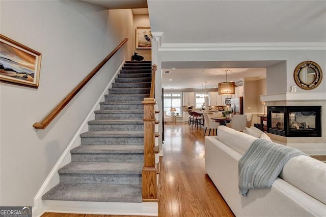 7435 Jamestown Dr, Alpharetta, GA 30005 - stairs featuring wood finished floors, ornamental molding, and a multi sided fireplace