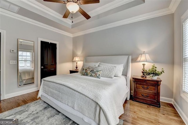 7435 Jamestown Dr, Alpharetta, GA 30005 - bedroom with a raised ceiling, multiple windows, wood finished floors, crown molding, and ceiling fan