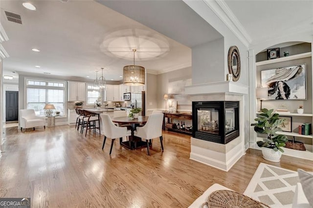 7435 Jamestown Dr, Alpharetta, GA 30005 - dining area with ornamental molding, a multi sided fireplace, light wood-style floors, and recessed lighting