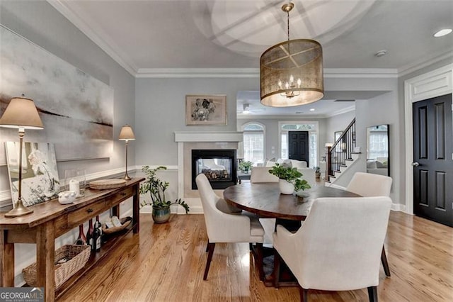 7435 Jamestown Dr, Alpharetta, GA 30005 - dining space featuring stairs, wood finished floors, a multi sided fireplace, and crown molding