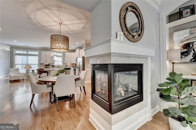 7435 Jamestown Dr, Alpharetta, GA 30005 - dining room with a chandelier, light wood finished floors, a multi sided fireplace, and recessed lighting