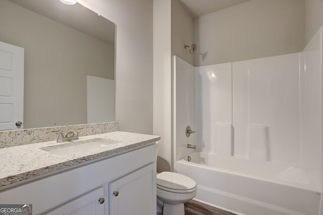 235 Annie Ln, Statham, GA 30666 - full bath with toilet, shower / bath combination, vanity, and wood finished floors