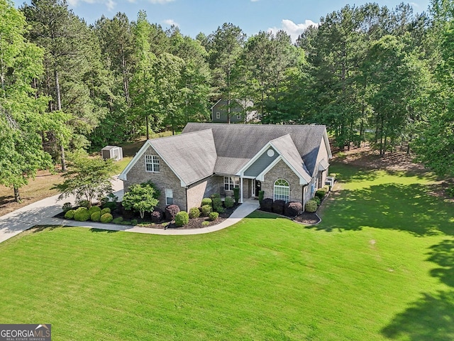 2305 Hawthorne Trce, Monroe, GA 30655 - view of front of property featuring stone siding, a front lawn, a storage unit, and an outdoor structure