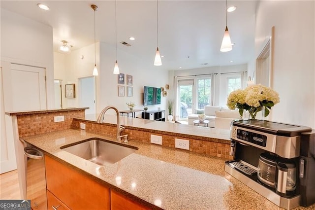 1430 Dresden Dr NE Unit 225, Atlanta, GA 30319 - kitchen featuring a sink, light stone countertops, dishwasher, tasteful backsplash, and decorative light fixtures