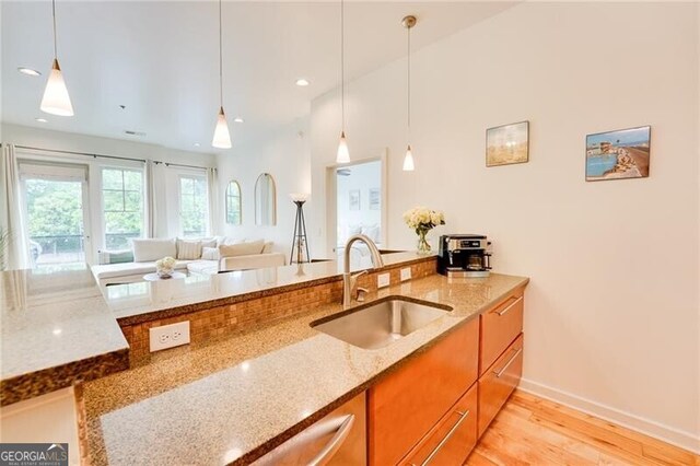 1430 Dresden Dr NE Unit 225, Atlanta, GA 30319 - kitchen with a sink, brown cabinets, light stone counters, pendant lighting, and recessed lighting