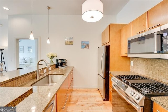 1430 Dresden Dr NE Unit 225, Atlanta, GA 30319 - kitchen featuring appliances with stainless steel finishes, a sink, light wood-style floors, light stone countertops, and tasteful backsplash