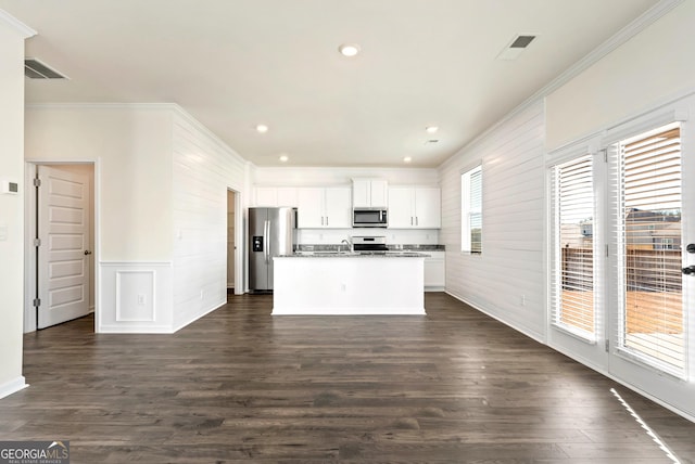 673 Graham Campbell Ln, Statham, GA 30666 - kitchen with stainless steel appliances, ornamental molding, an island with sink, white cabinets, and dark wood finished floors