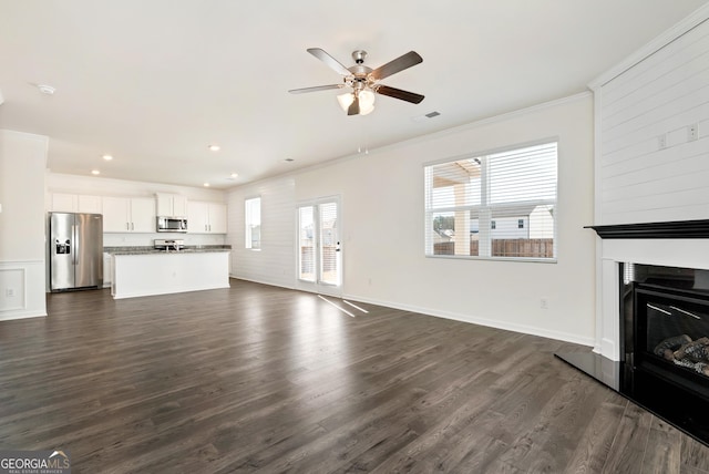 673 Graham Campbell Ln, Statham, GA 30666 - unfurnished living room with crown molding, a glass covered fireplace, a ceiling fan, dark wood-style flooring, and recessed lighting