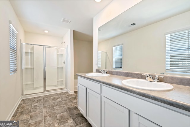 673 Graham Campbell Ln, Statham, GA 30666 - bathroom with a shower stall, double vanity, recessed lighting, and stone finish flooring