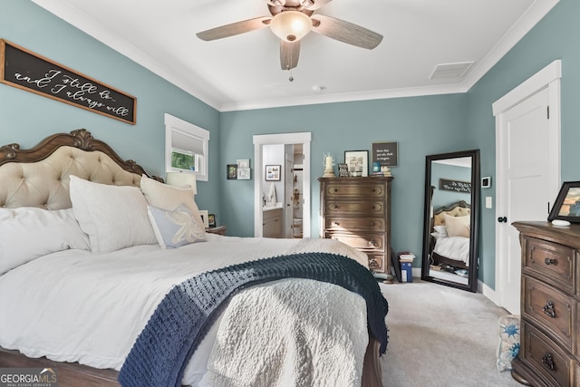 bedroom featuring ornamental molding, light colored carpet, ceiling fan, ensuite bathroom, and baseboards