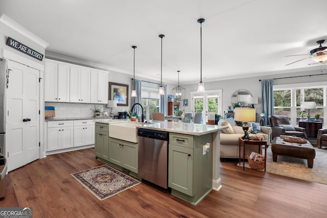 kitchen with stainless steel dishwasher, a sink, green cabinetry, dark wood-type flooring, and white cabinetry
