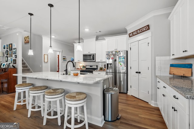 kitchen featuring stainless steel appliances, crown molding, decorative backsplash, white cabinetry, and dark wood-style floors