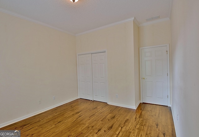 44 Arbor Way, Newnan, GA 30265 - unfurnished bedroom featuring wood finished floors, crown molding, a closet, and a textured ceiling