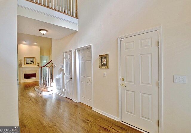 44 Arbor Way, Newnan, GA 30265 - entrance foyer with wood finished floors, baseboards, a fireplace, and stairway
