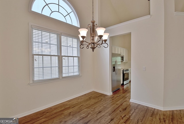 44 Arbor Way, Newnan, GA 30265 - unfurnished dining area featuring a chandelier, high vaulted ceiling, light wood-style floors, and baseboards
