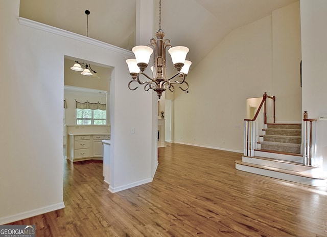 44 Arbor Way, Newnan, GA 30265 - unfurnished dining area featuring wood finished floors, lofted ceiling, stairway, a chandelier, and baseboards