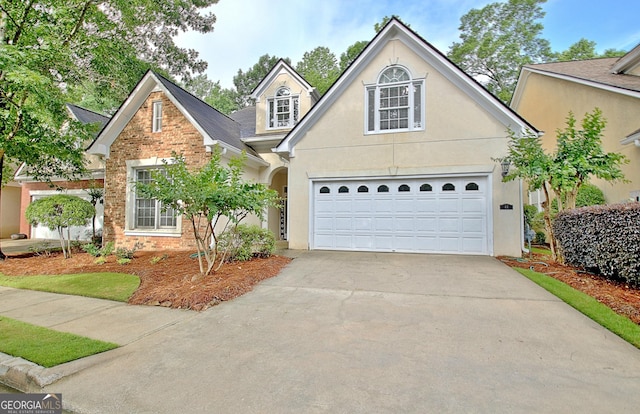 44 Arbor Way, Newnan, GA 30265 - traditional-style house with driveway, a garage, brick siding, and stucco siding